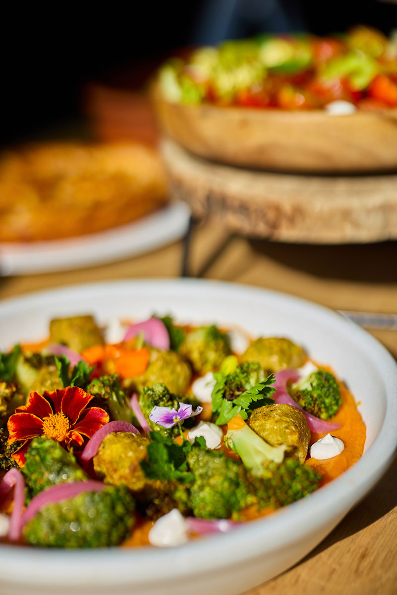 assiette-brocolis-fleur-orange-table-bois Gros plan sur une assiette joliment décorée