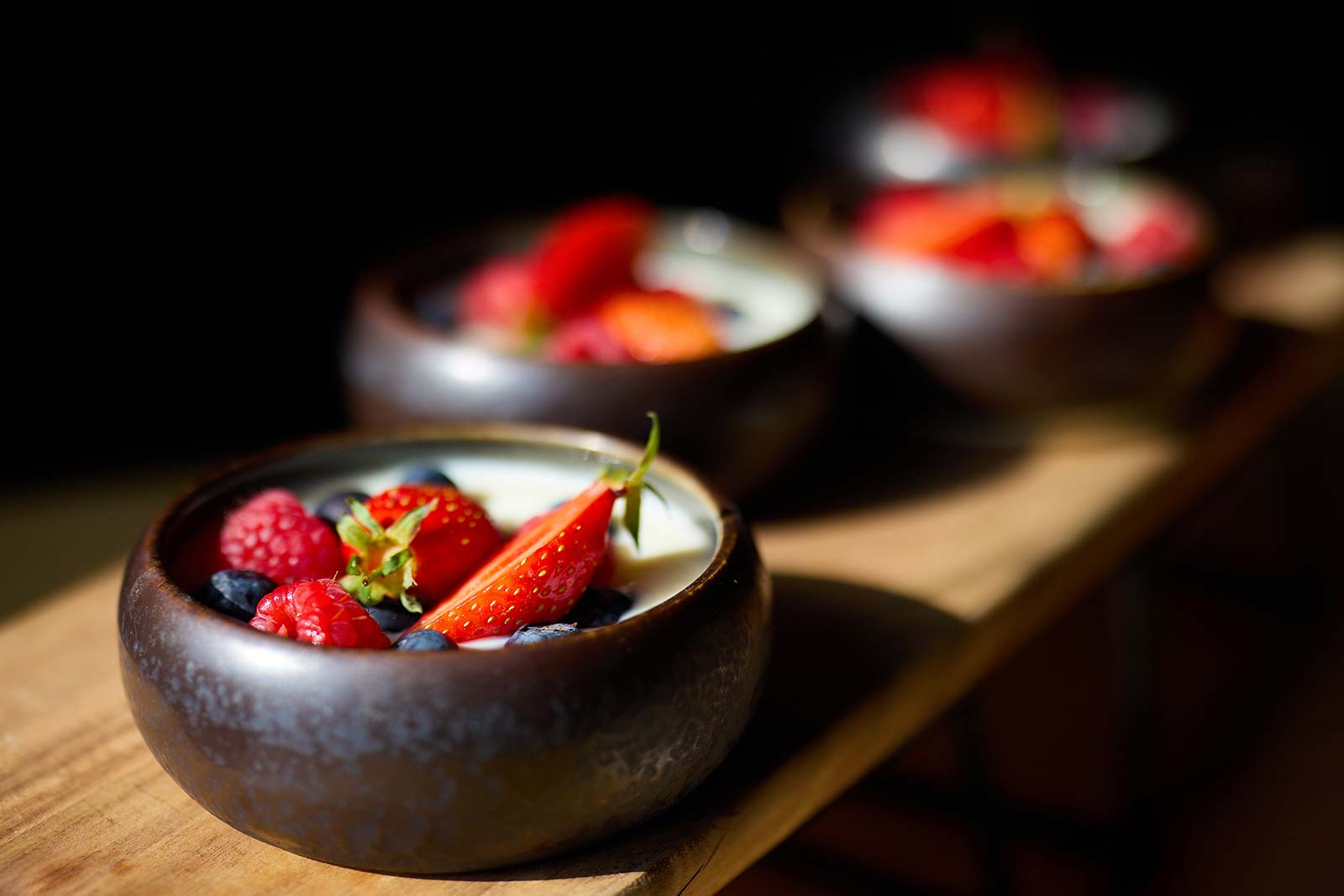 Desserts aux fruits rouges dans 2 bols noirs